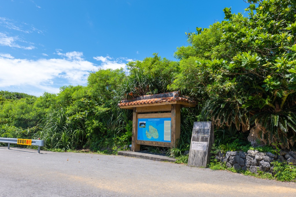 下地島護岸入口の観光案内サインと駐車スペース 青空と緑に囲まれた沖縄離島の風景