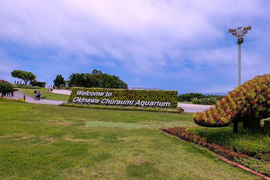 海洋博公園入口の「Welcome to Okinawa Churaumi Aquarium」緑の植栽サイン