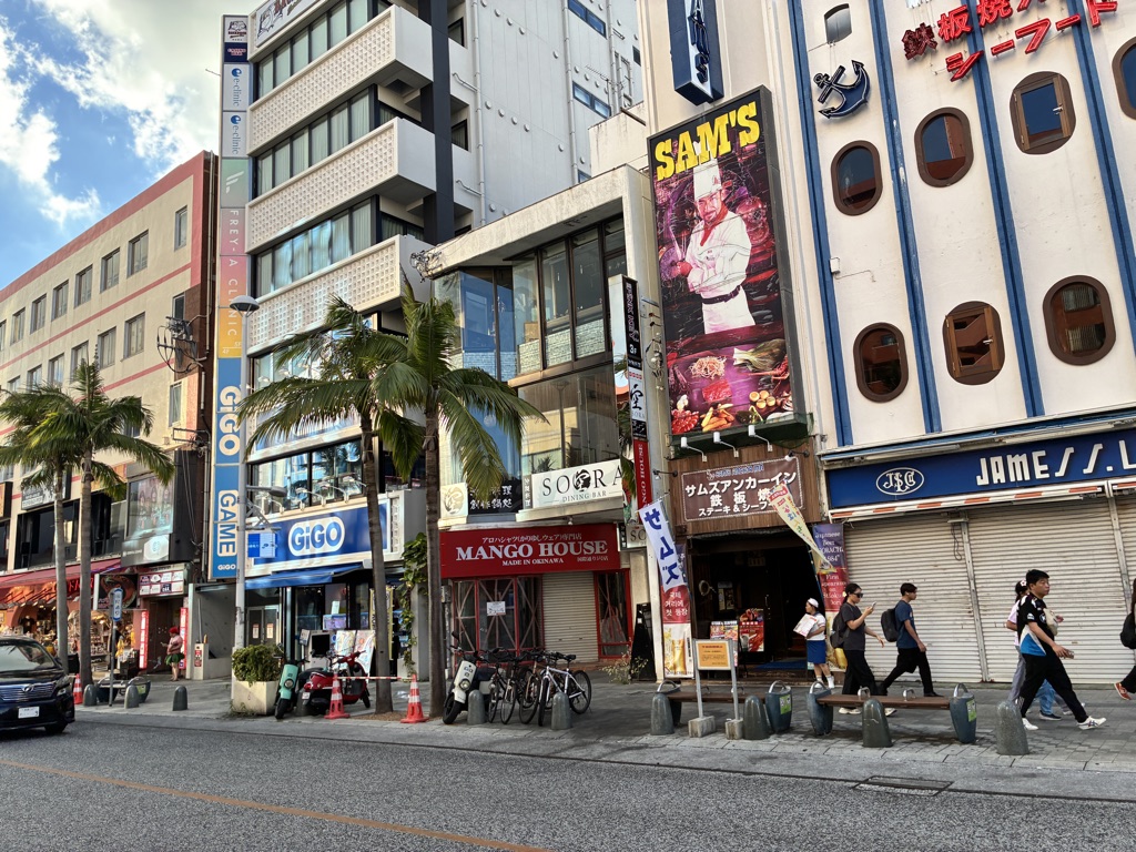 国際通りのゲームセンター・SAM'Sステーキ店など沖縄の観光通り風景