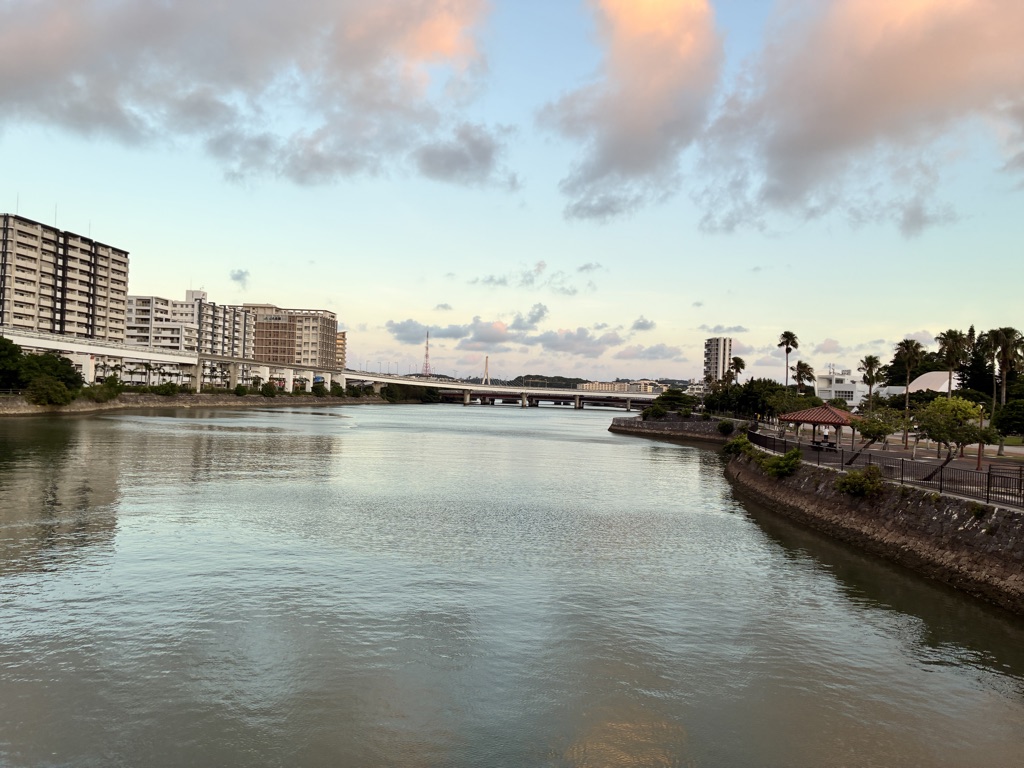 穏やかな川沿いのマンション群と夕焼けの空が広がる日本の都市風景
