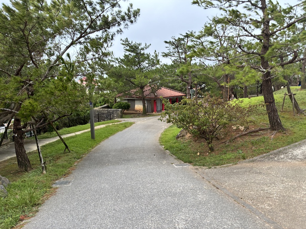 松並木と赤瓦の建物が見える首里城公園の無料区域の遊歩道