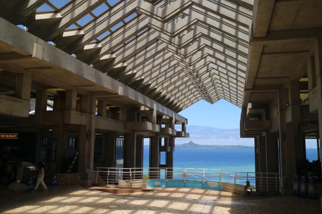 美ら海水族館入館前のオーシャンビューロビー 三角屋根の格子越しに広がる青い海と伊江島