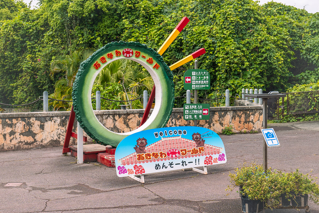 おきなわワールド入口のICOタイヤモニュメントと「めんそーれー!!」の案内看板