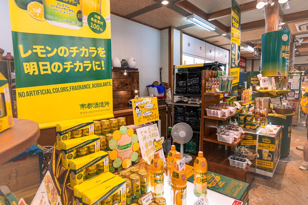 シークヮーサー特設コーナー — 「レモンのチカラを明日のチカラに!」の黄色い縦看板と果汁ボトル陳列