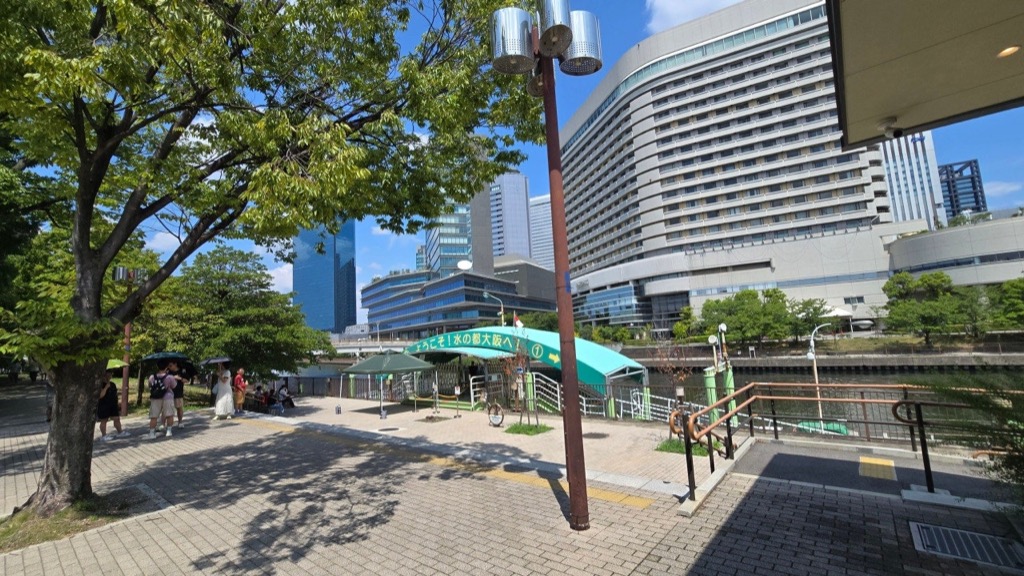 日傘をさして歩く人と濃い木陰 — 9月上旬の大阪、真夏と変わらない強い日差し