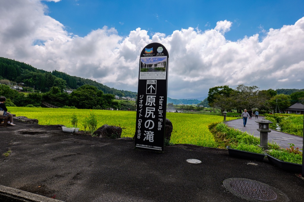 田んぼを背景に立つ原尻の滝の案内看板