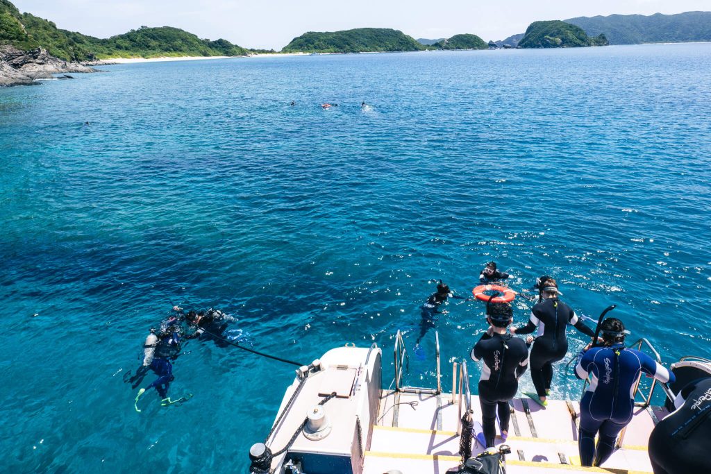 慶良間の海でダイビングボートからエントリーするダイバーたち