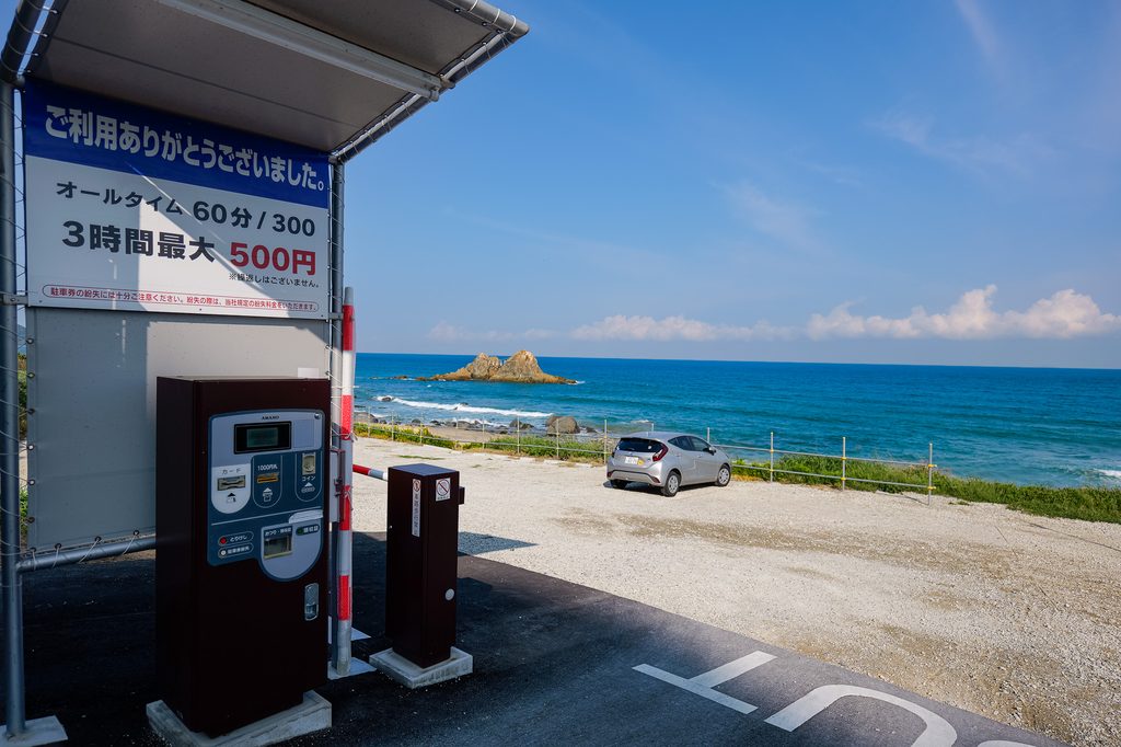 大注連縄掛祭の当日、氏子たちが海に入り新しい注連縄を岩に掛ける瞬間。伝統行事の躍動感が伝わる場面