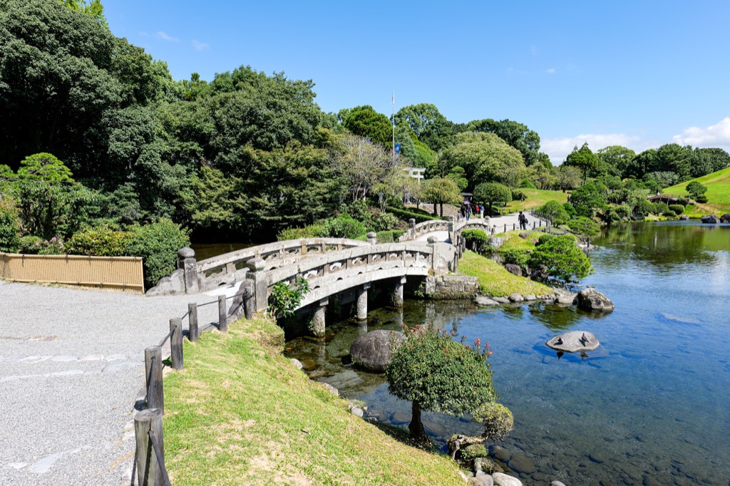 水前寺成趣園の池と石橋、手入れされた庭園風景