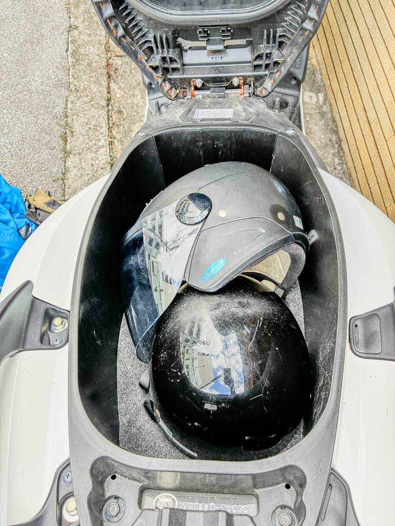 スクーターのシート下にヘルメットを収納した様子